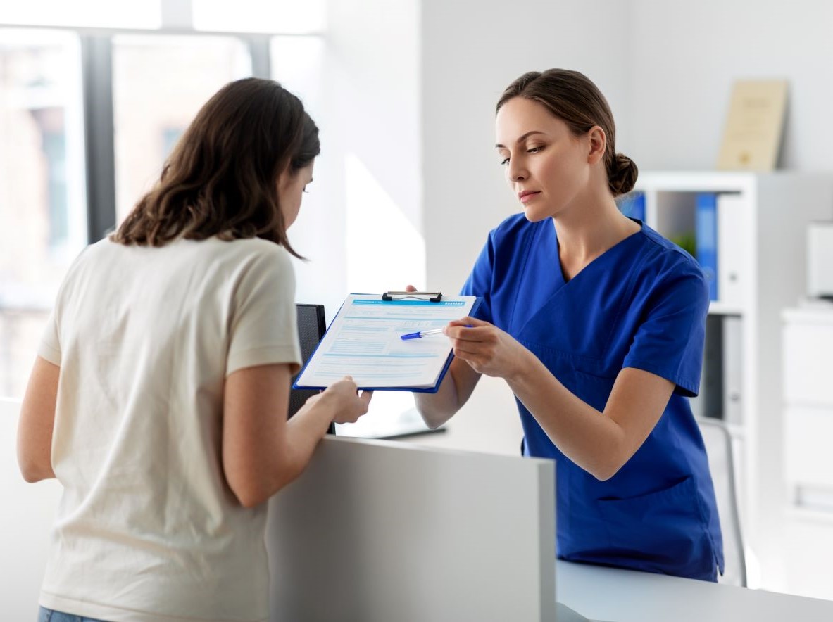 Une infirmière montre un document à une patiente.
